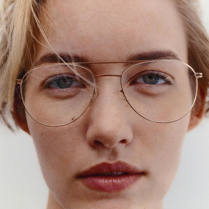 Femme portant des lunettes rondes dorées à monture métallique Mykita — Bar à Lunettes Québec